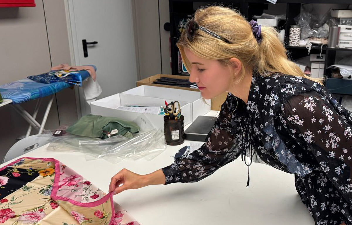 Jowita Lamberty prüft den Rand eines Seidentuchs mit Blumenmotiv