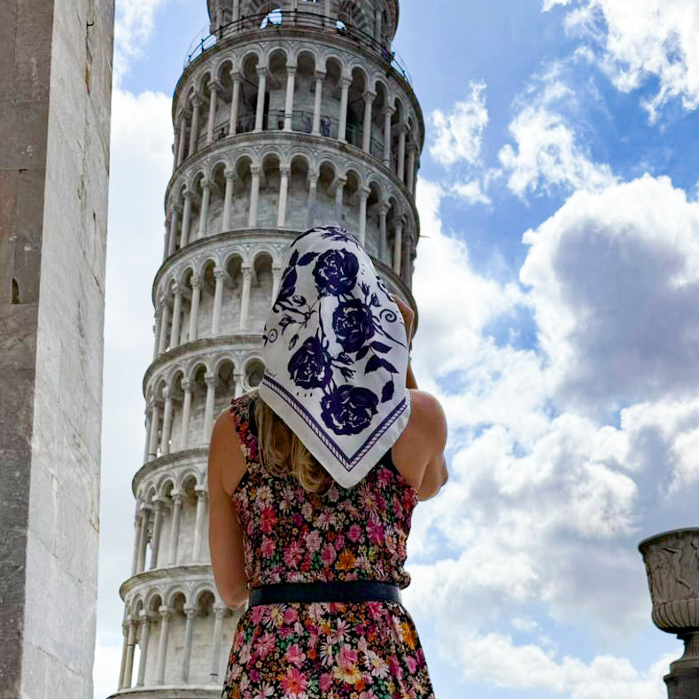 Frau von hinten vor dem Schiefen Turm von Pisa trägt das beige Twilight Rose Tuch über Kopf und Schultern